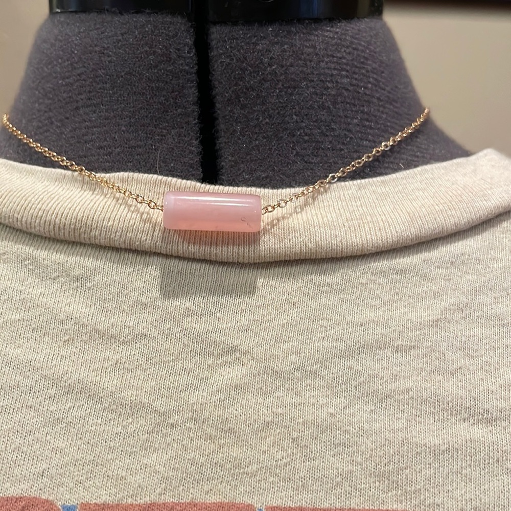 This is a pink crystal necklace with a gold chain